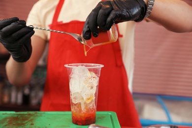 Photo of Male bartender preparing refreshing drink at table, closeup