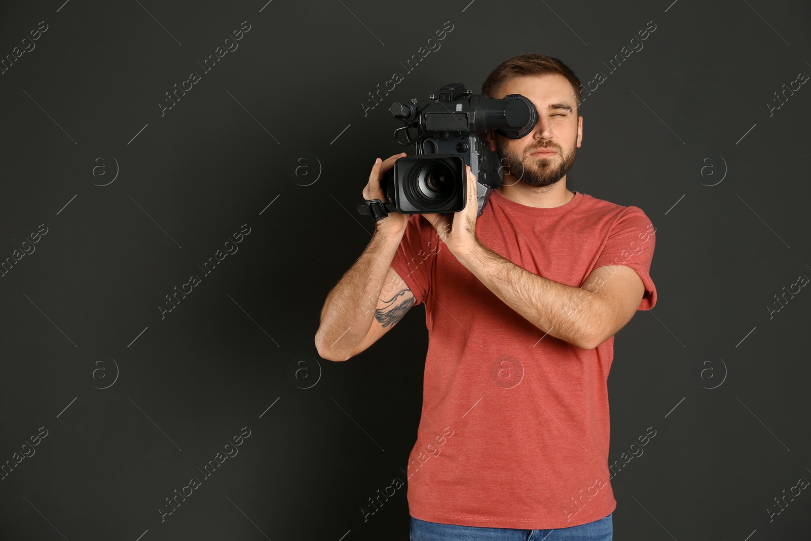 Photo of Operator with professional video camera on black background