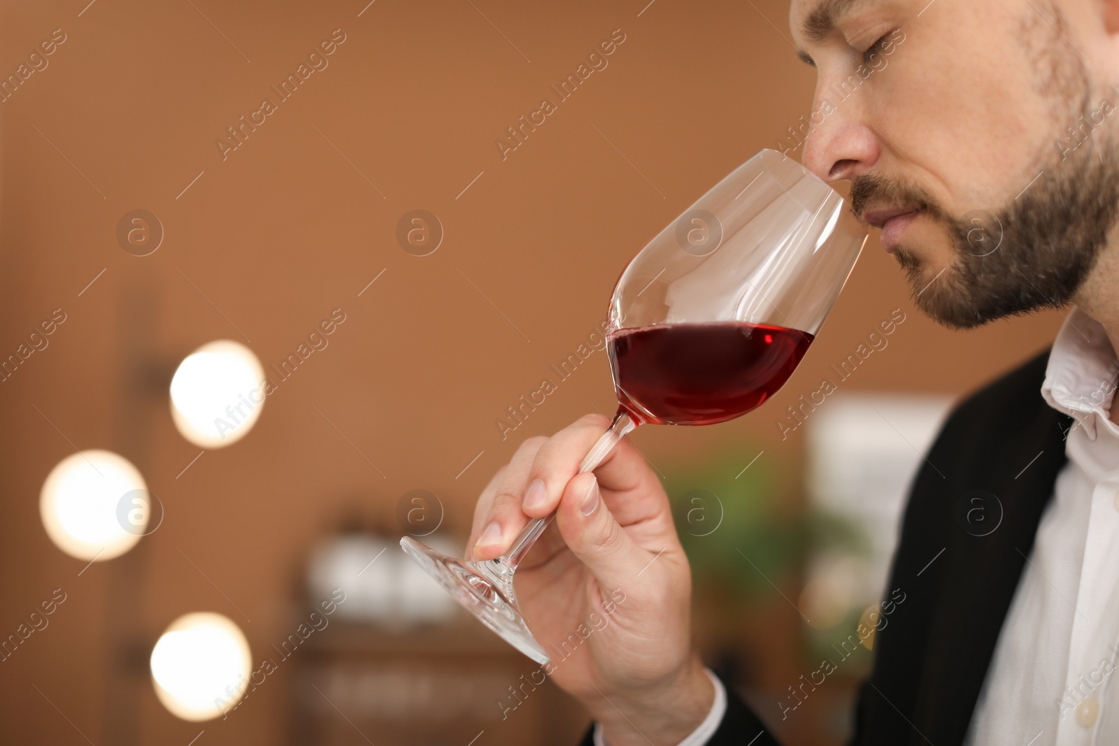 Photo of Young man with glass of wine indoors