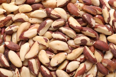 Photo of Many delicious Brazil nuts as background, top view