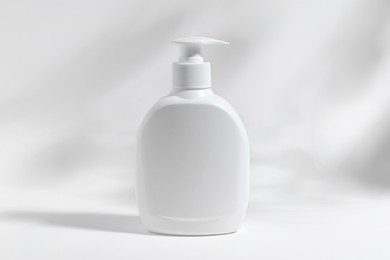Photo of Bottle with cosmetic product on white background