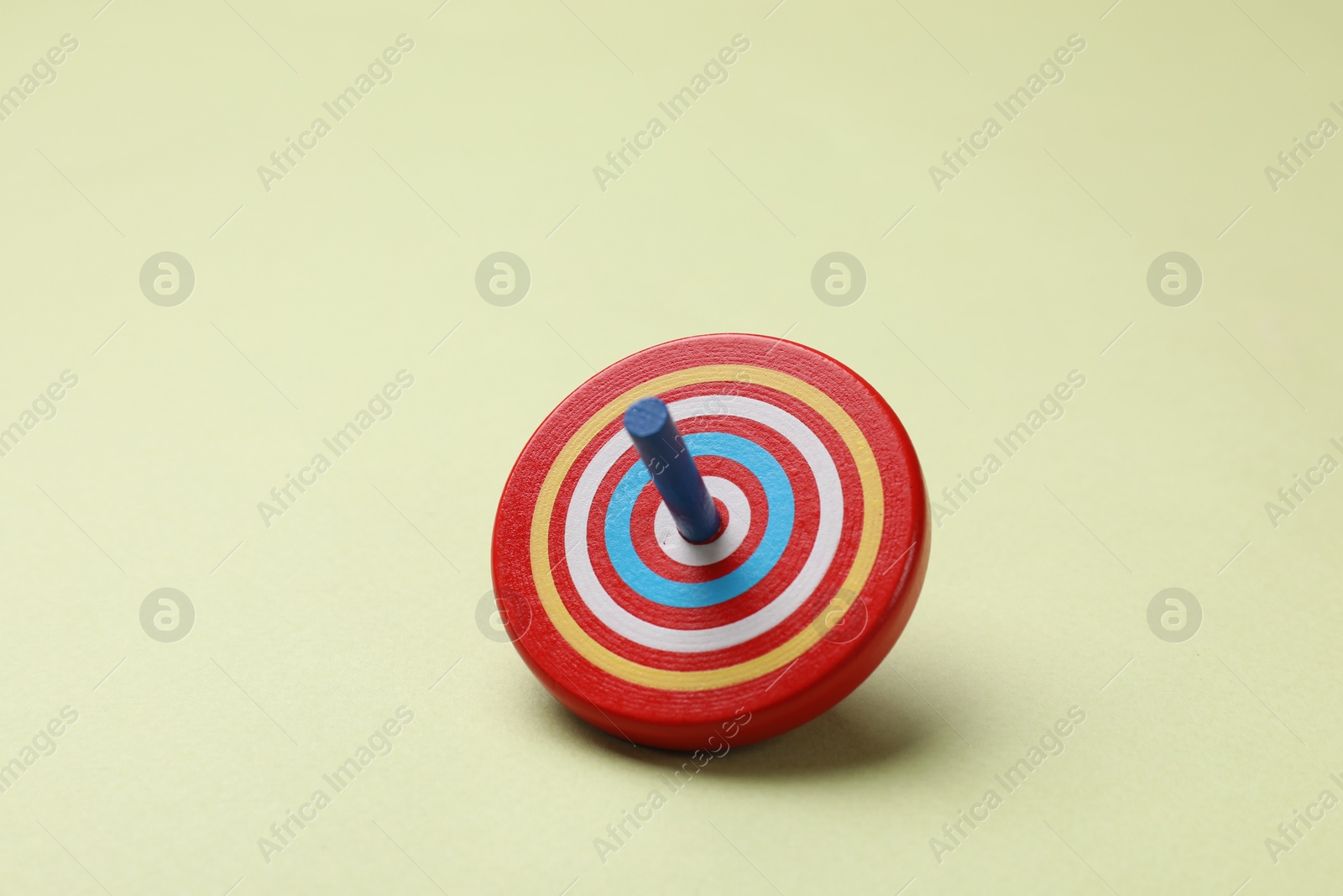 Photo of One colorful spinning top on green background