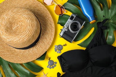 Photo of Flat lay composition with beach accessories on yellow background