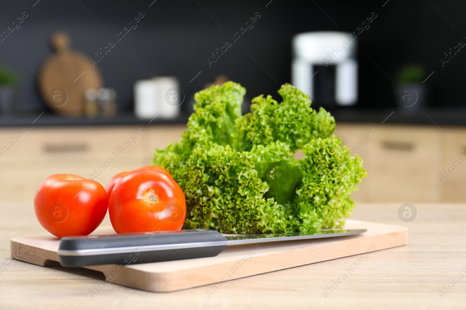 Photo of Fresh vegetables on wooden table in kitchen