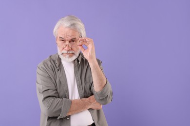 Portrait of stylish grandpa with glasses on purple background, space for text