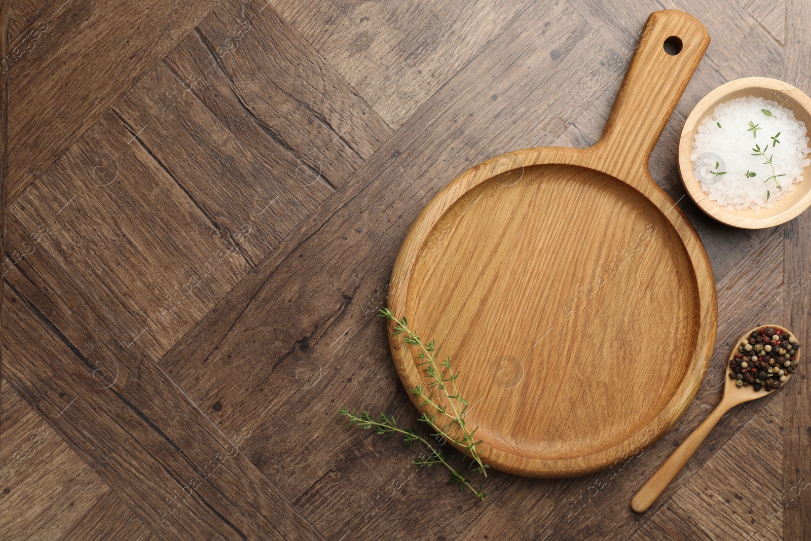 Photo of Cutting board and different spices on wooden table, flat lay. Space for text