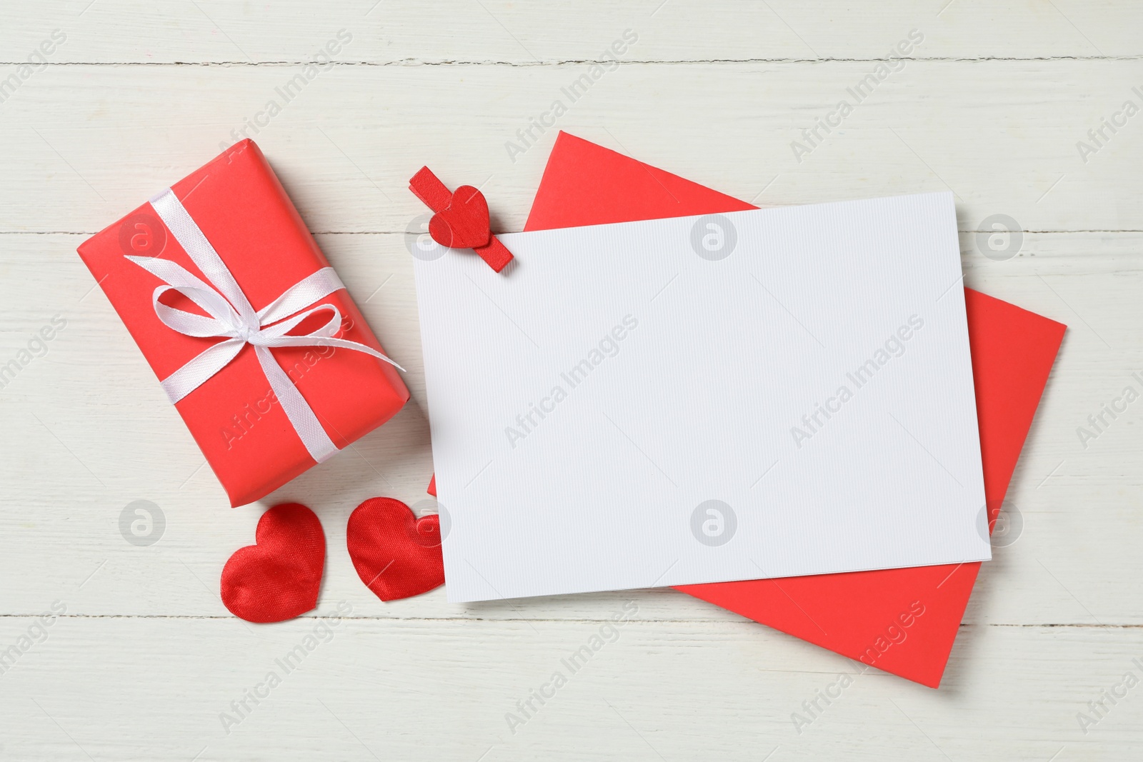 Photo of Flat lay composition with blank card on white wooden  background, space for text. Valentine's Day celebration