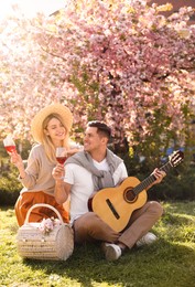 Lovely couple having picnic in park on sunny spring day