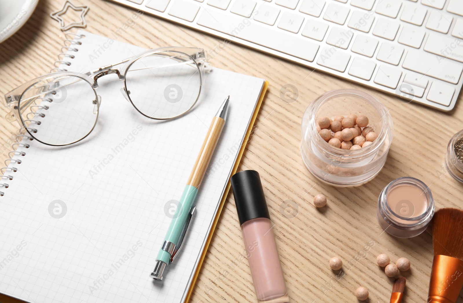 Photo of Composition with blank notebook and cosmetics on wooden table. Blogger's workplace