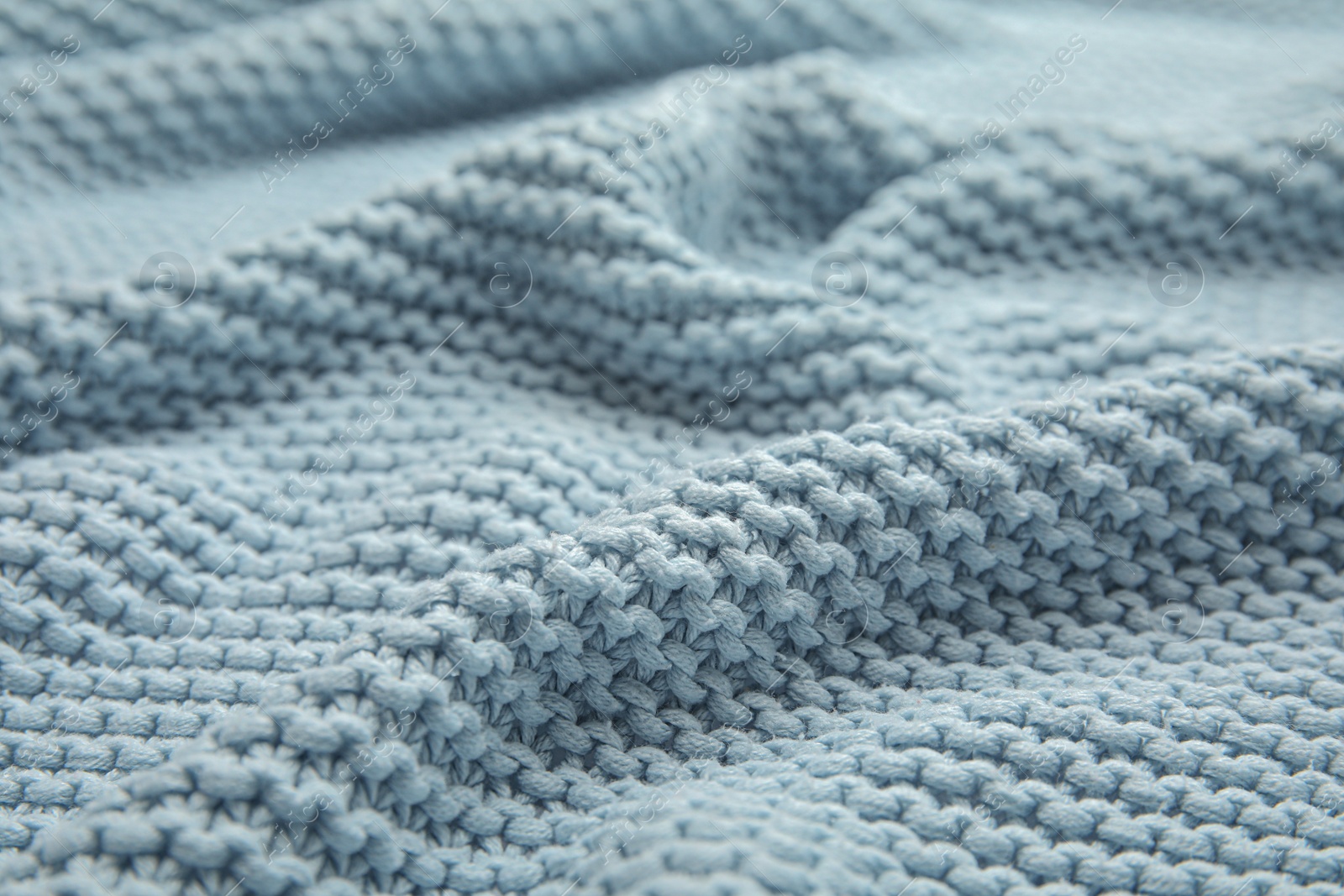 Photo of Soft light blue knitted plaid as background, closeup