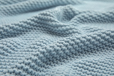 Soft light blue knitted plaid as background, closeup