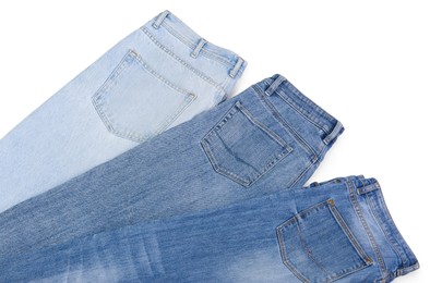 Photo of Different stylish jeans isolated on white, above view