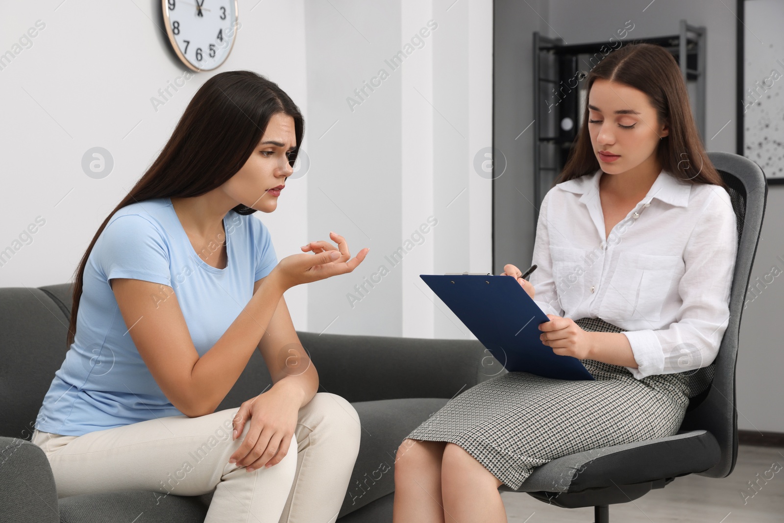 Photo of Professional psychologist working with young woman in office