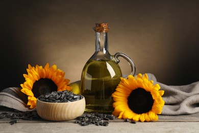 Photo of Sunflower cooking oil, seeds and yellow flowers on light grey table