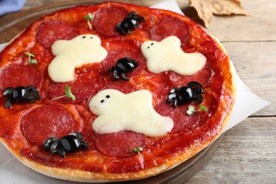 Cute Halloween pizza with ghosts and spiders served on wooden table, closeup