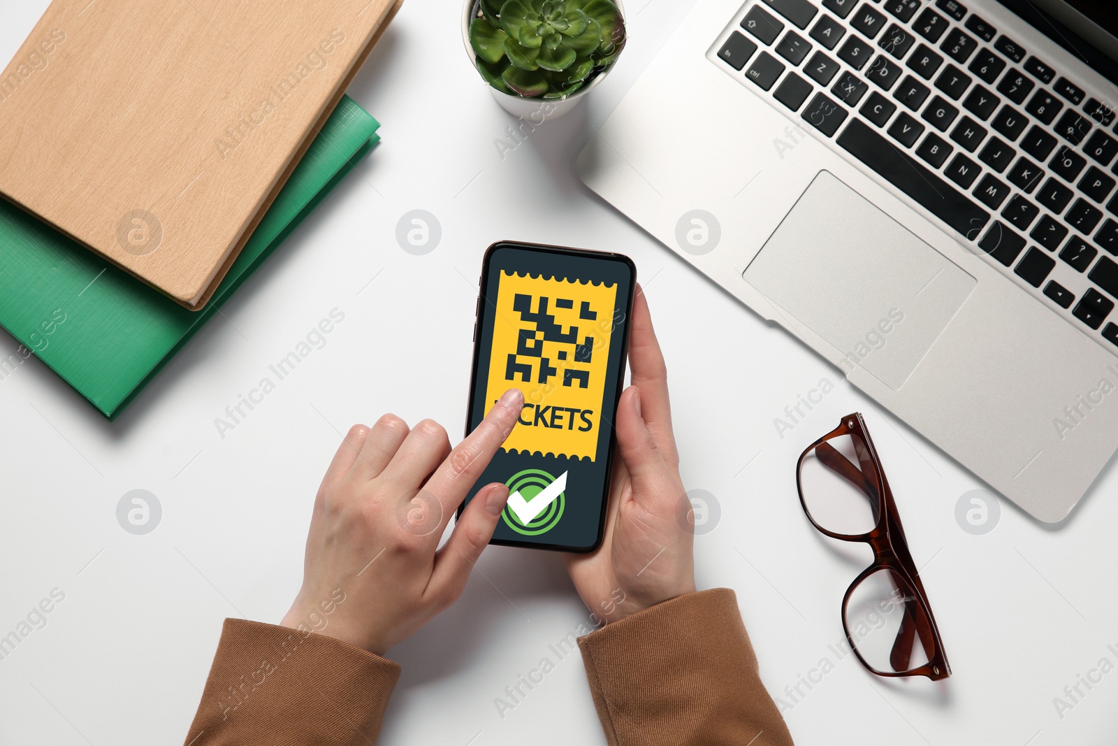 Image of Woman buying cinema tickets online via mobile phone at table, top view