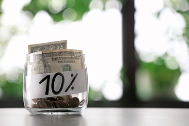 Photo of 10 PERCENT written on paper and money in jar against blurred background, space for text
