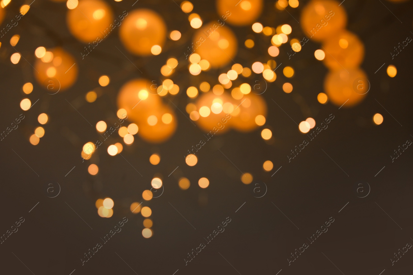 Photo of Blurred view of gold lights on dark background. Bokeh effect