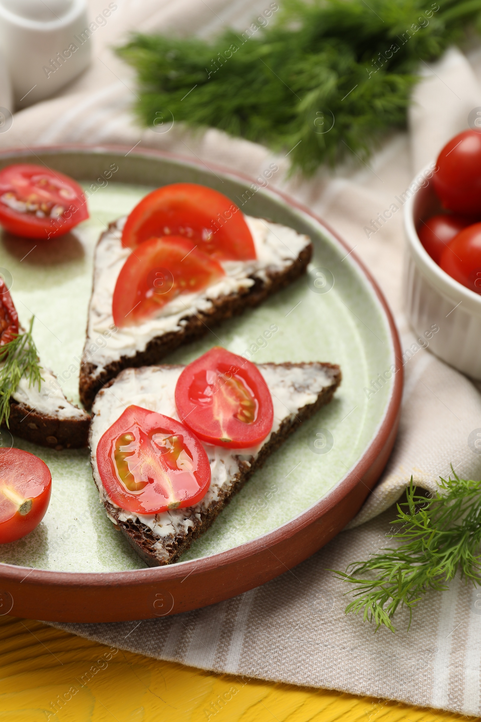 Photo of Delicious bruschettas with ricotta cheese, dill and tomatoes on yellow wooden table, closeup