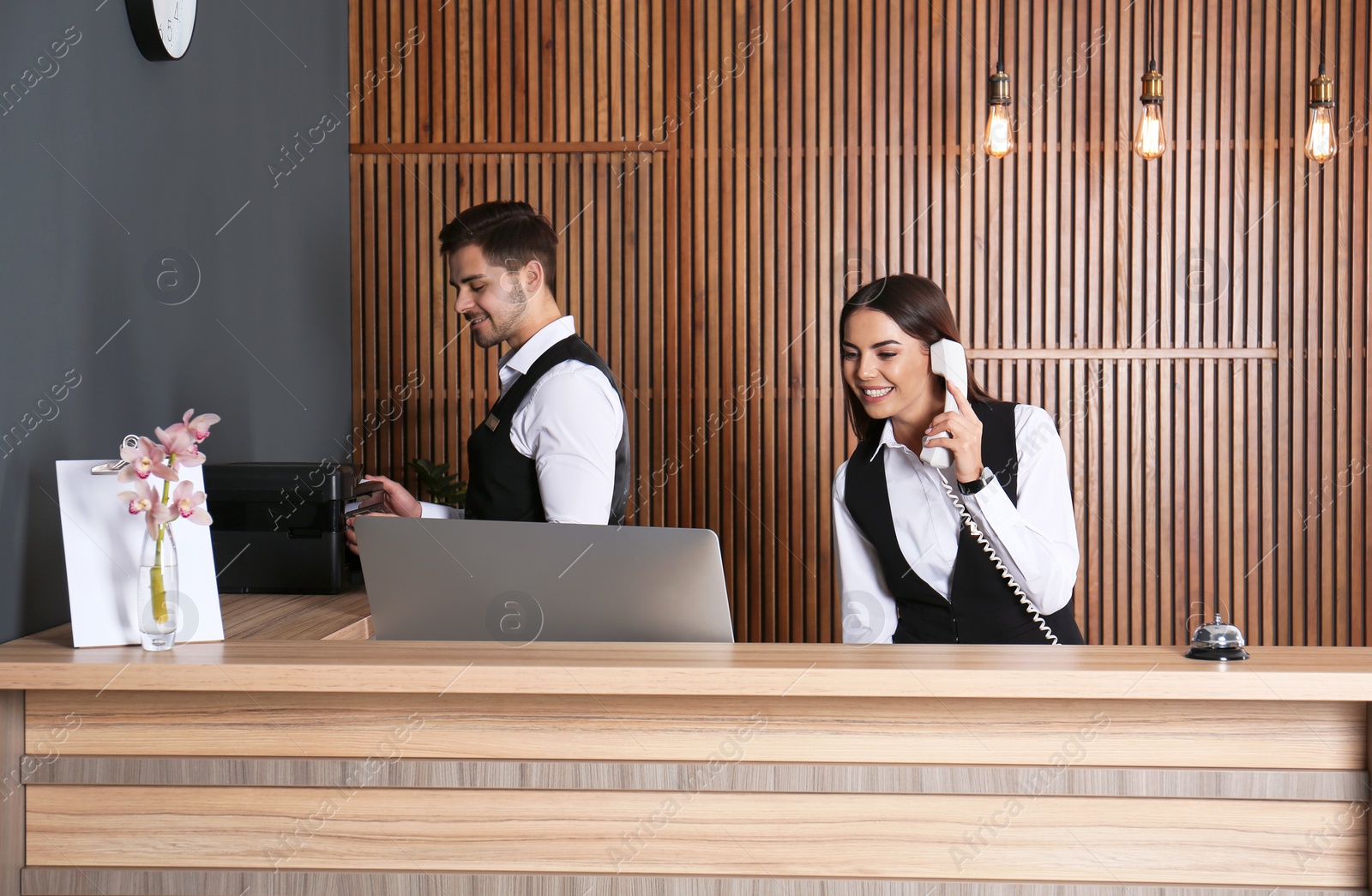Photo of Receptionists working at desk in modern lobby