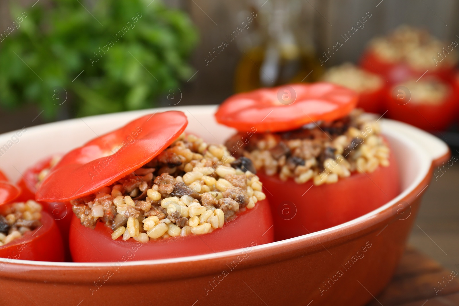 Photo of Delicious stuffed tomatoes with minced beef, bulgur and mushrooms in baking dish, closeup