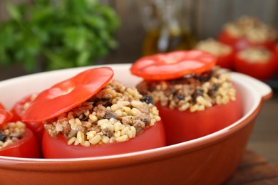 Photo of Delicious stuffed tomatoes with minced beef, bulgur and mushrooms in baking dish, closeup