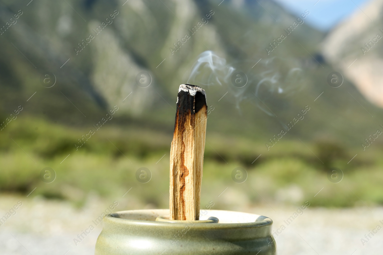 Photo of Burning palo santo stick in high mountains, closeup