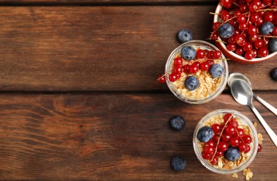 Photo of Delicious yogurt parfait with fresh berries on wooden table, flat lay. Space for text