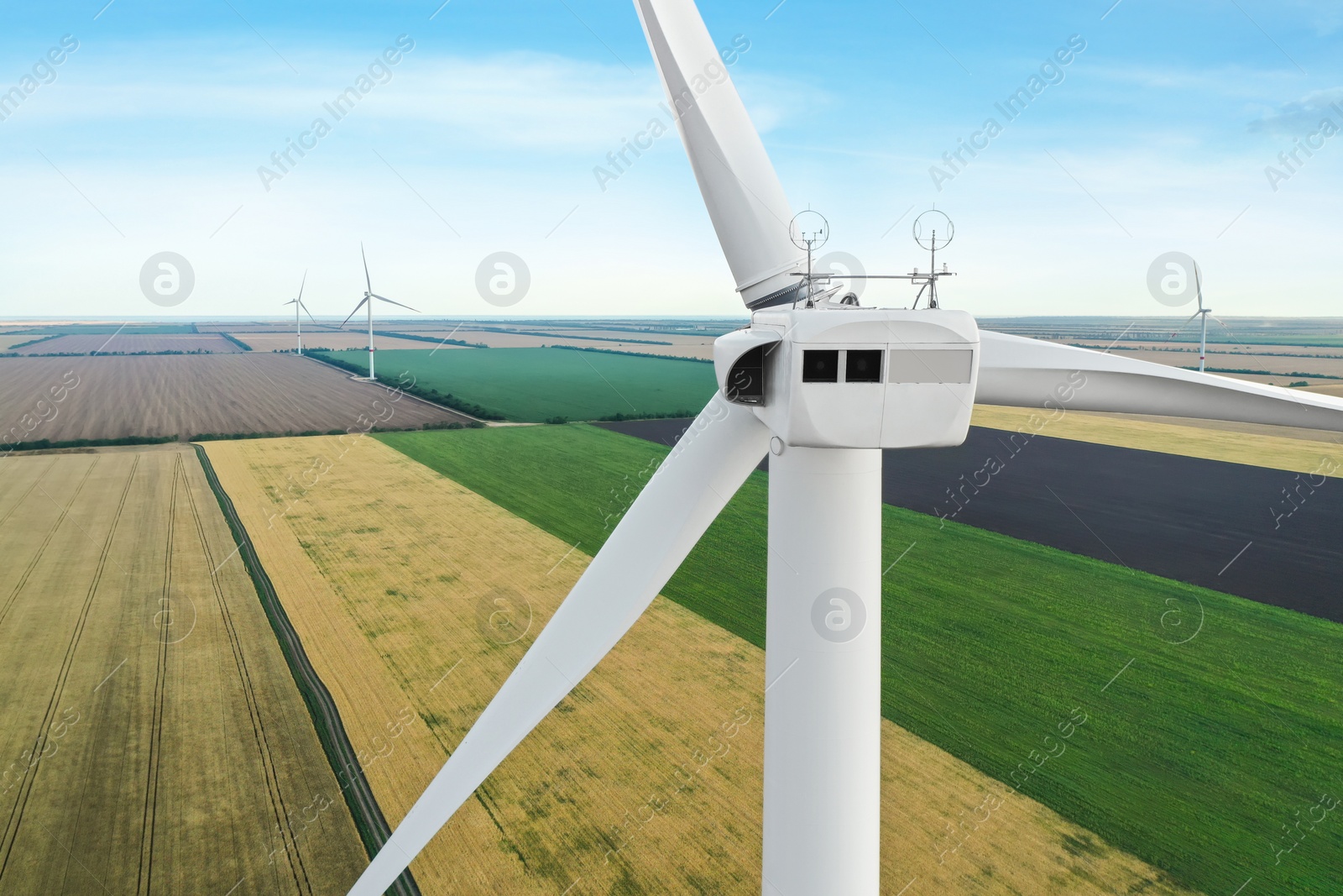 Photo of Modern windmill in wide field, closeup. Energy efficiency