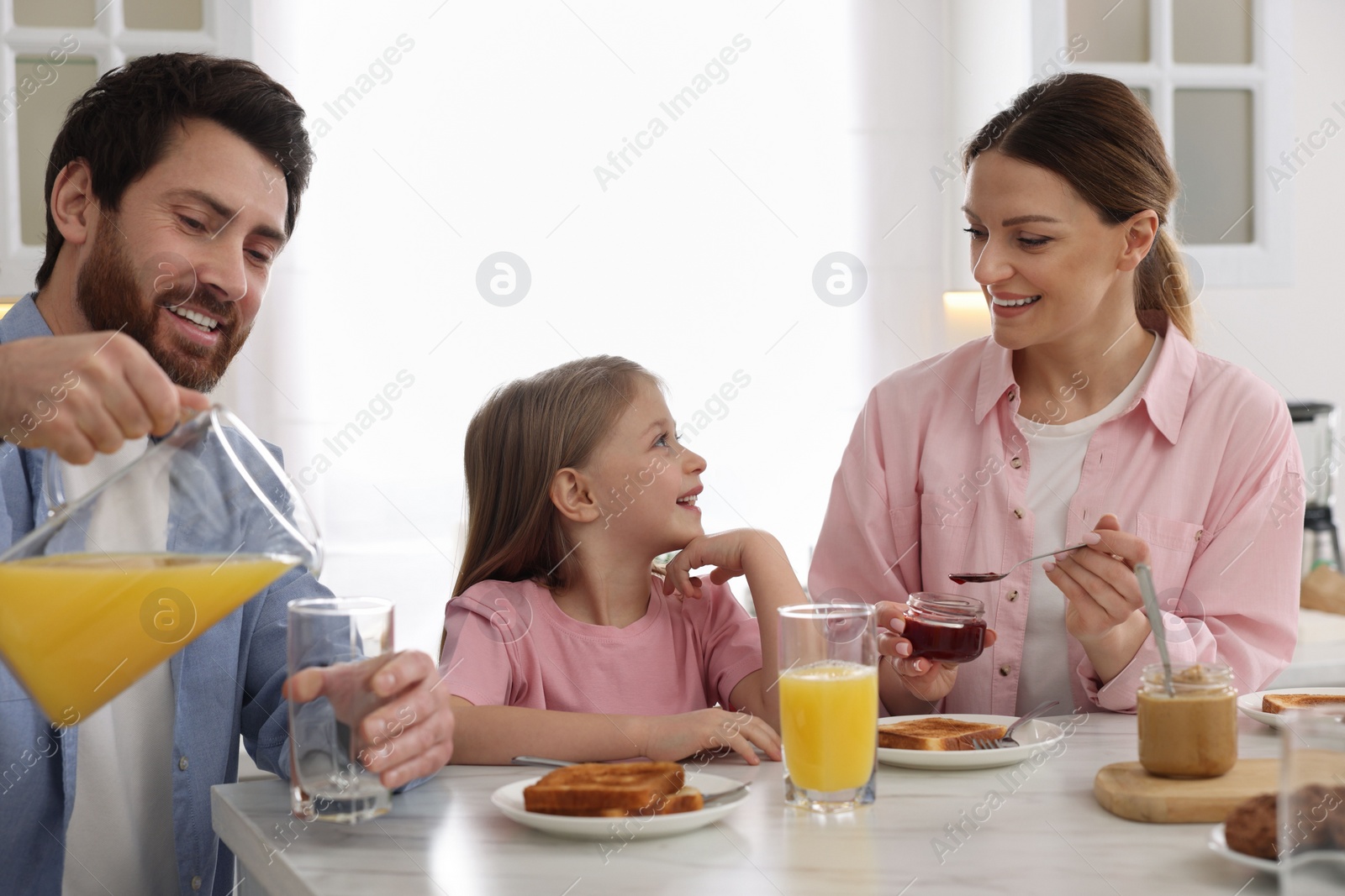 Photo of Happy family having breakfast at table in kitchen