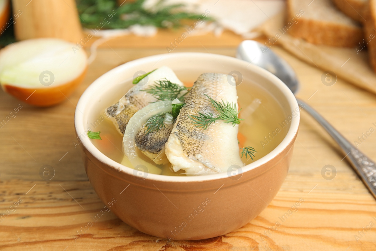 Photo of Delicious fish soup in bowl on wooden table, closeup