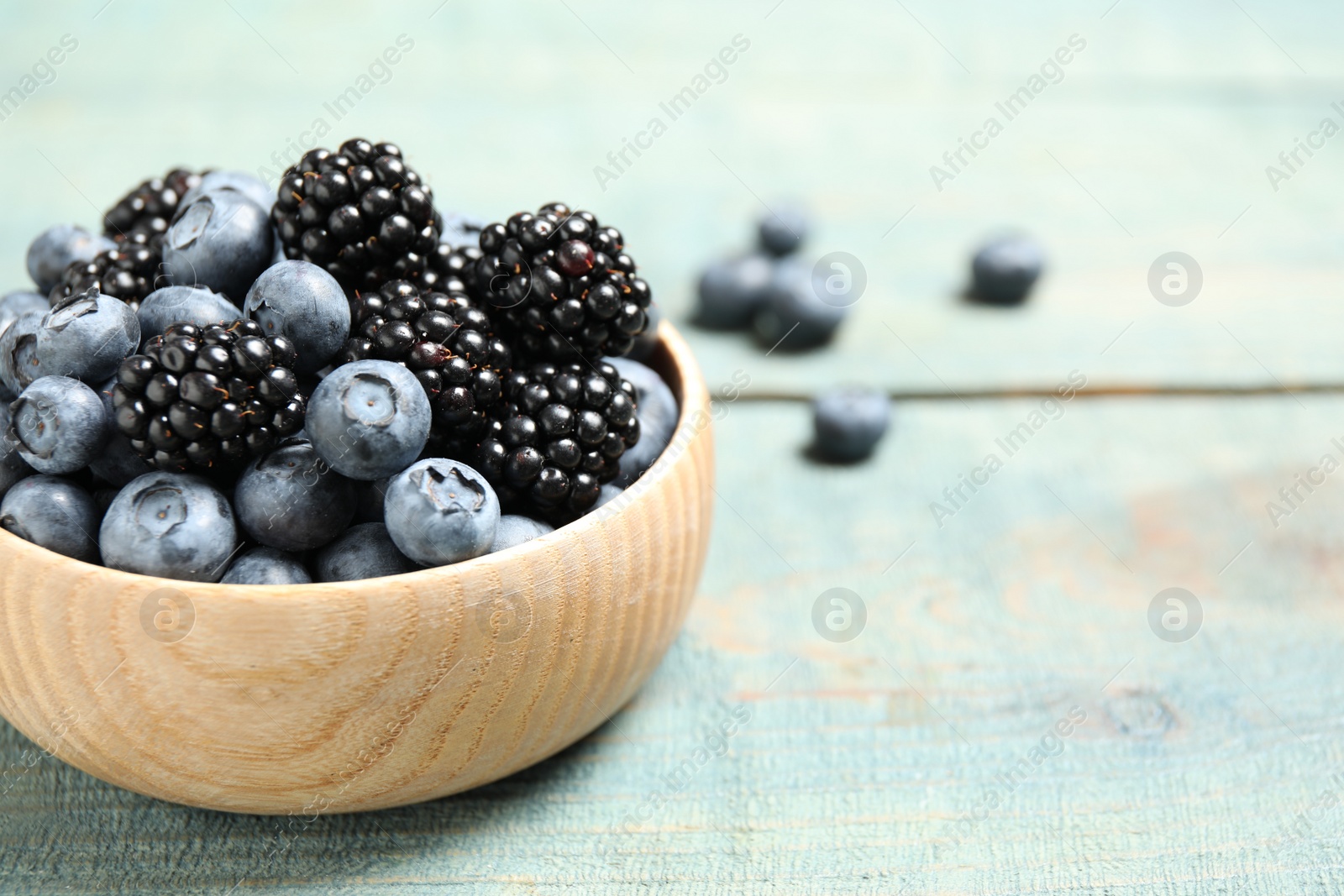 Photo of Mix of ripe berries in bowl, closeup. Space for text