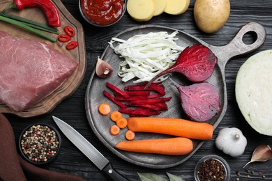 Photo of Fresh ingredients for borscht on black wooden table, flat lay