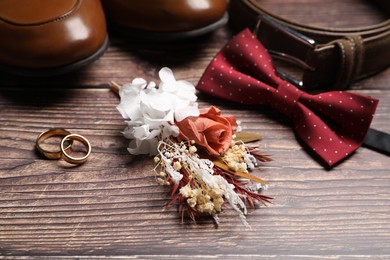 Wedding stuff. Composition with stylish boutonniere on wooden background, closeup