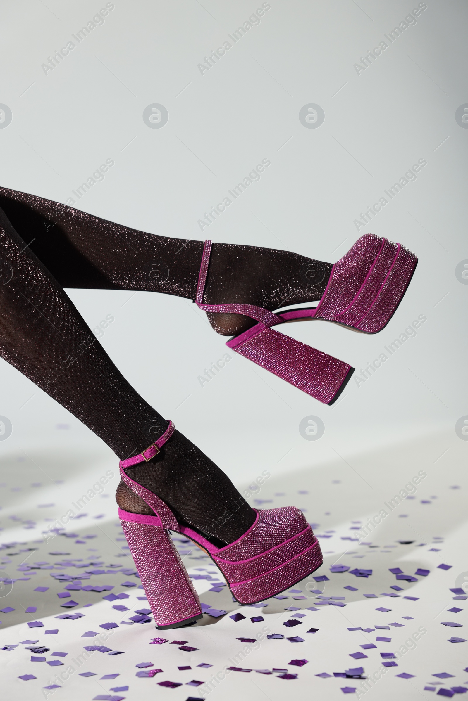 Photo of Stylish party. Woman wearing pink high heeled shoes with platform and square toes on light grey background, closeup