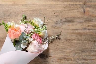 Bouquet of beautiful flowers on wooden table, top view. Space for text