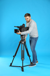 Photo of Operator with professional video camera on blue background