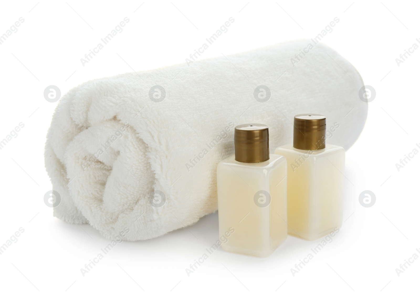 Photo of Mini bottles with cosmetic products and towel on white background. Hotel amenities