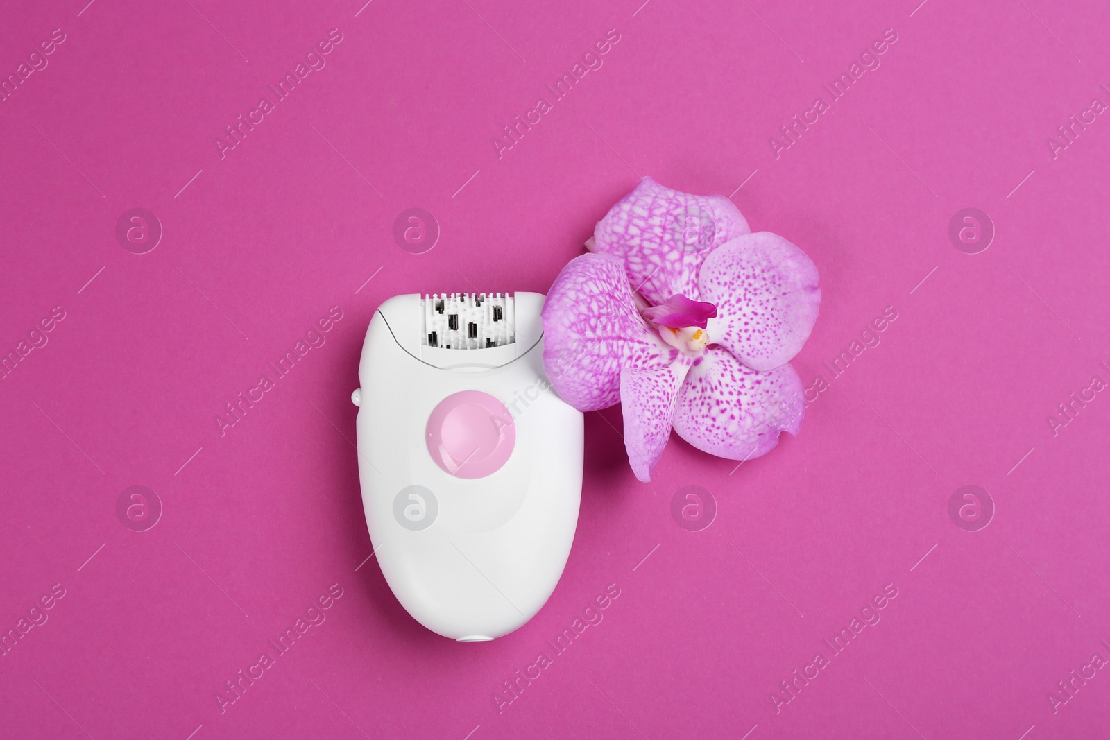 Photo of Modern epilator and flower on purple background, flat lay