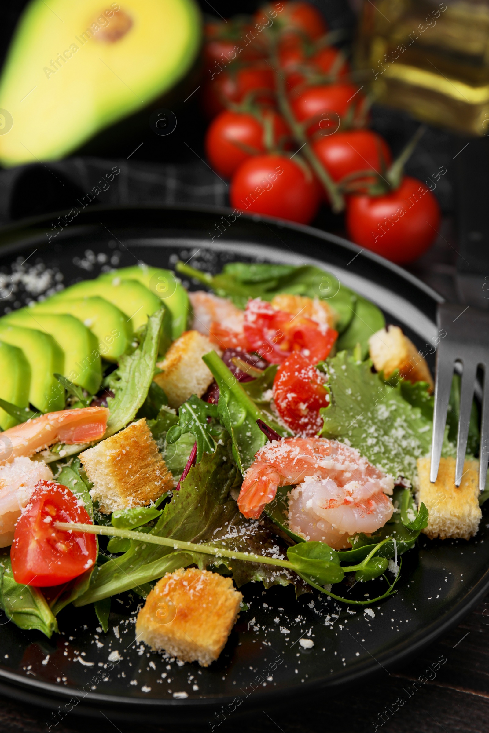 Photo of Delicious salad with croutons, avocado and shrimp served on table, closeup