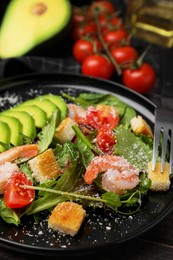 Photo of Delicious salad with croutons, avocado and shrimp served on table, closeup