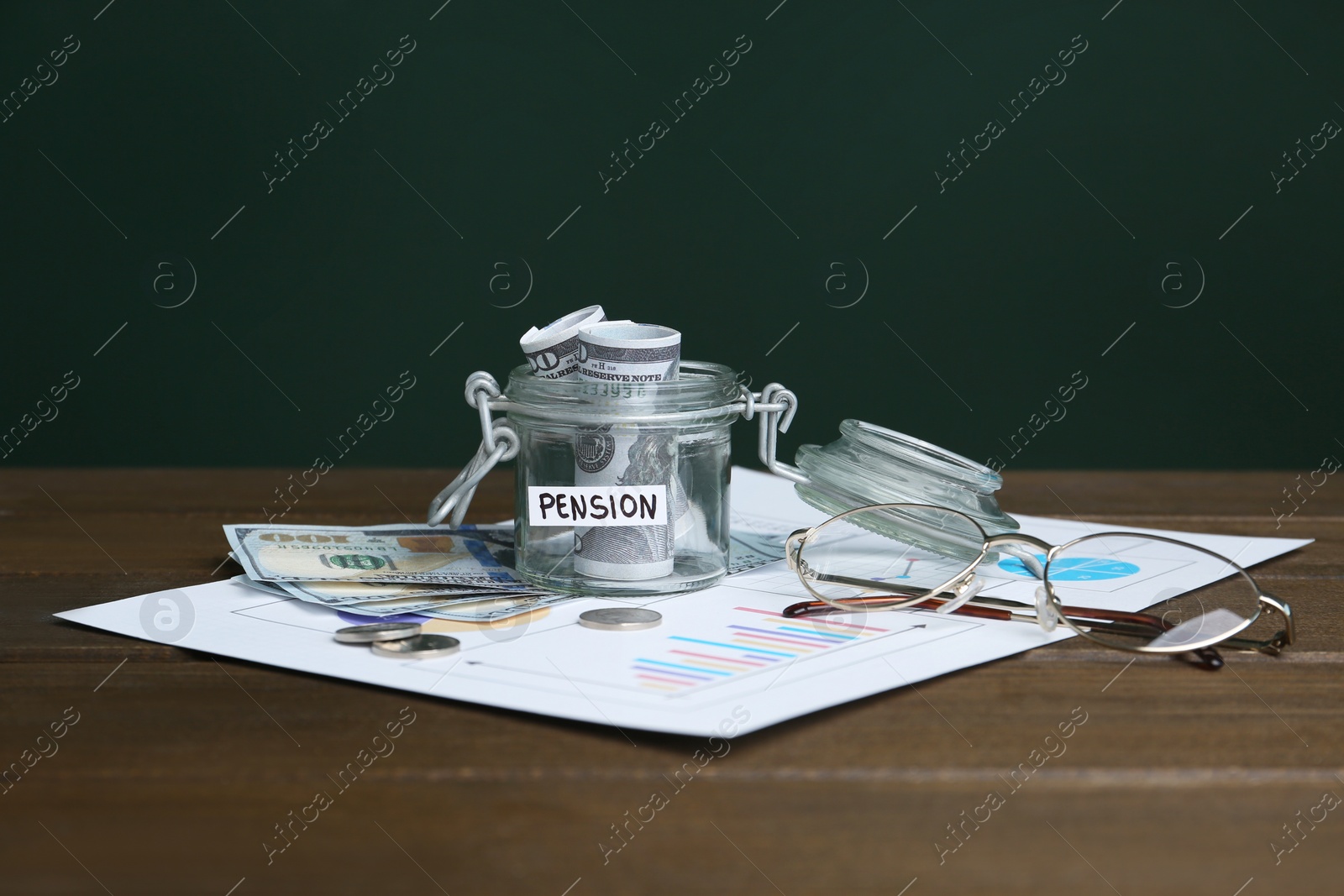 Photo of Glass jar with word Pension, money and glasses on wooden table