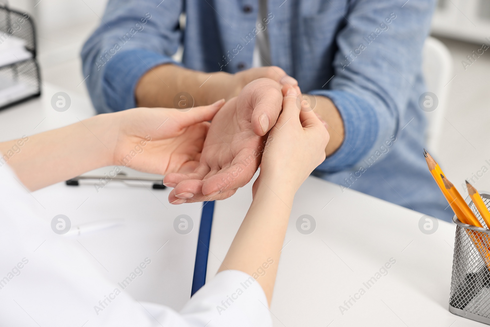 Photo of Arthritis symptoms. Doctor examining patient's wrist in hospital, closeup