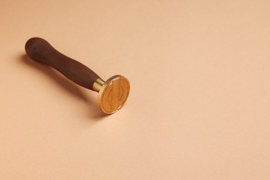 Photo of One stamp tool with wooden handle on light brown background. Space for text