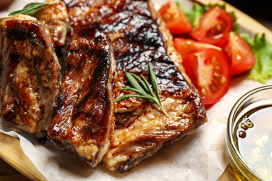 Photo of Delicious grilled ribs with rosemary on table, closeup