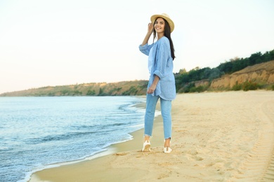 Photo of Beautiful young woman in casual outfit on beach