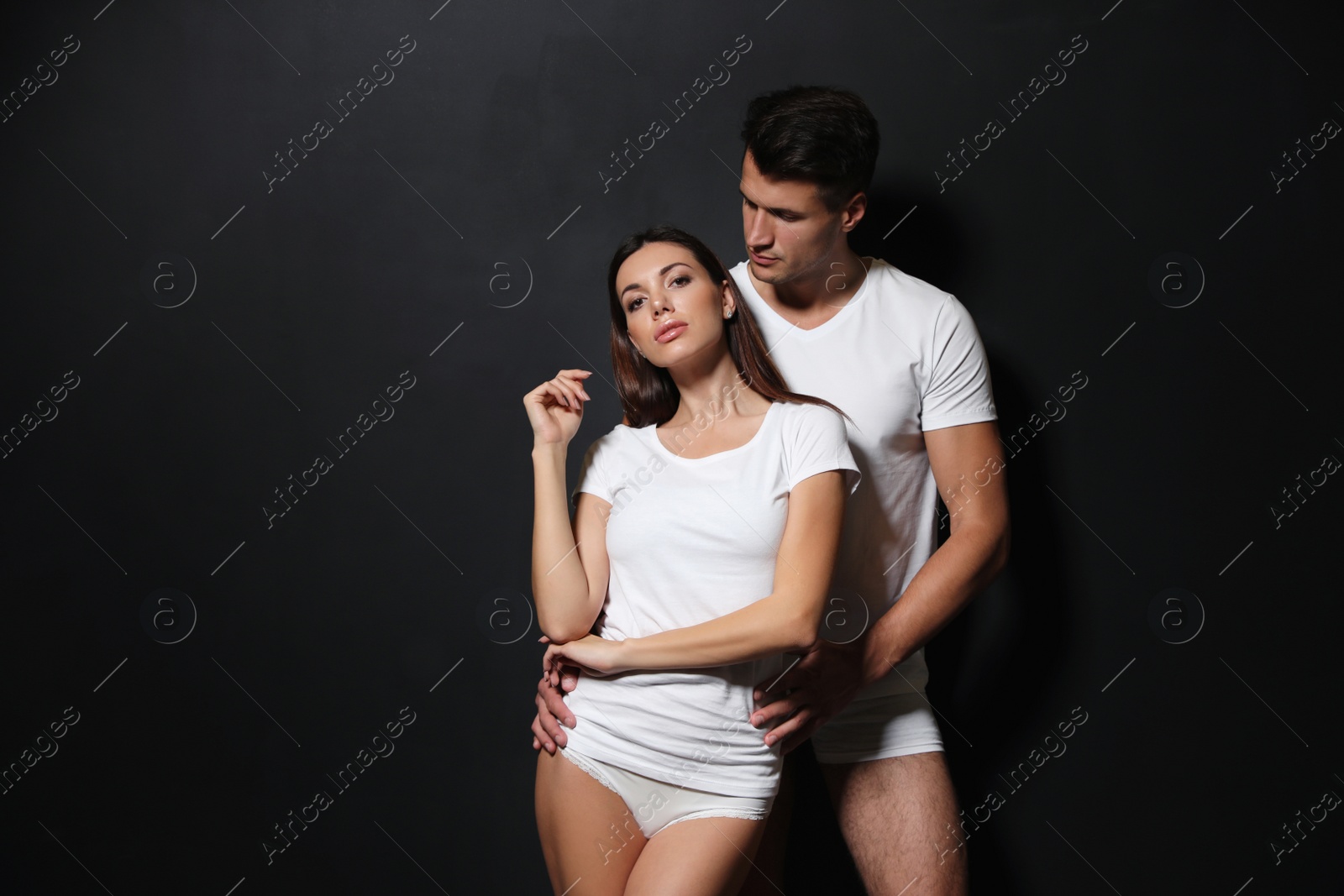 Photo of Young couple wearing underwear on black background