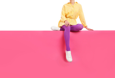 Photo of Woman wearing bright tights and stylish shoes sitting on color background, closeup. Space for text