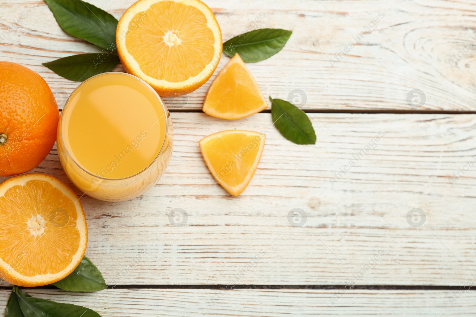 Photo of Delicious orange juice and fresh fruits on white wooden table, flat lay. Space for text