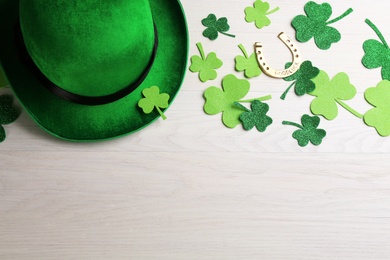 Photo of Flat lay composition with leprechaun hat on white wooden table, space for text. St Patrick's Day celebration